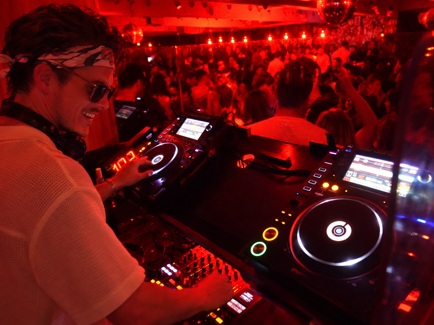 ROOM:SRVC DJ Sascha playing a tech house set in a crowded club with red lighting